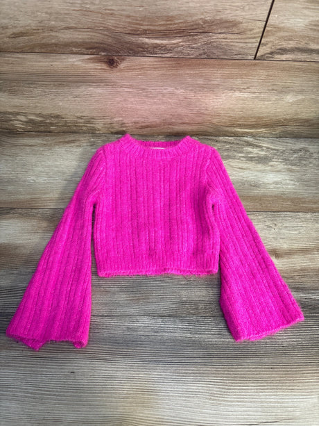 Bright pink ribbed knit long sleeve crop sweater for kids on wooden background