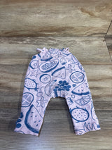 Flat-lay of newborn pink Cat & Jack jumpsuit showcasing blue fruit print and ruffle collar on wood floor background