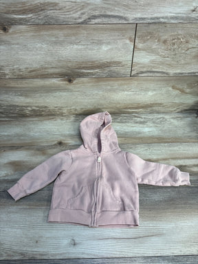 Light pink baby hoodie with zipper and front pockets on wood floor background