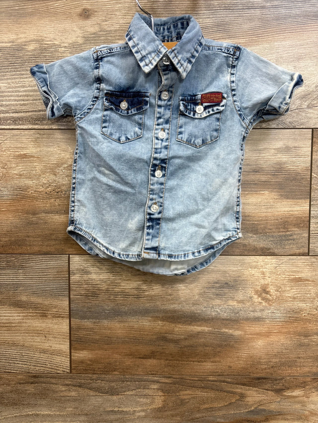 Front view of 7 For All Mankind denim button-down shirt, size 12M, showing chest pockets and faded blue wash on wood floor