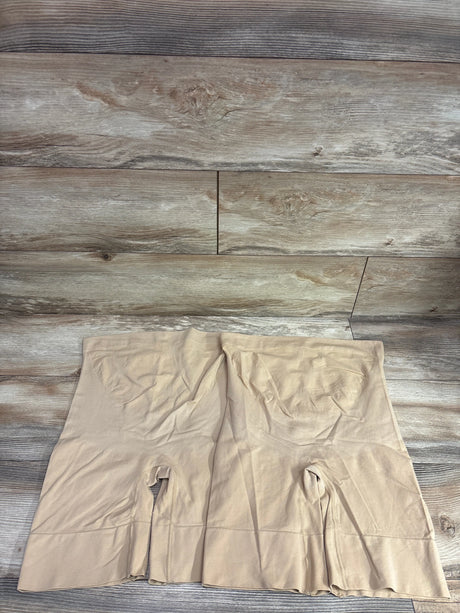 Top view of beige seamless maternity shapewear shorts showcasing the high waist and longer legs on a wood-look floor