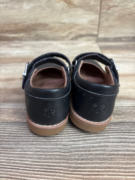 Rear view of Stride Rite Mara Mary Jane flats in black, size 7C, showcasing ankle straps and tan soles on wood