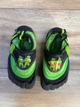 Green and black toddler shoes with cartoon ninja turtle characters on wooden floor