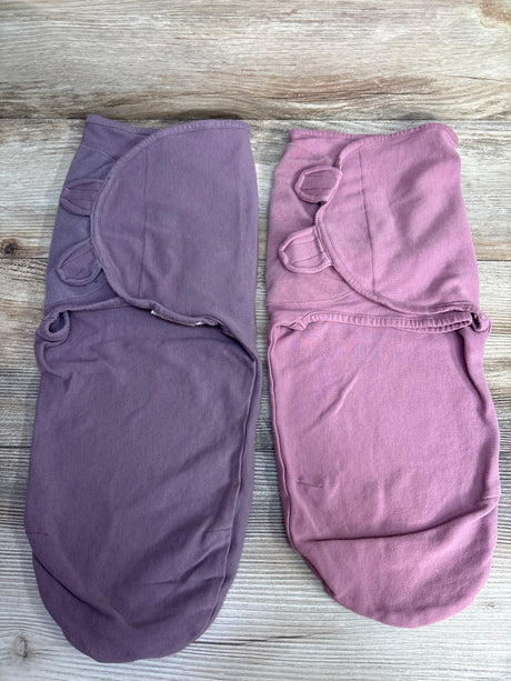 Two soft cotton baby swaddle wraps in purple and pink on wood background with ear details