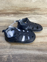 Angled side view of Just One You Harrison fisherman sandals in navy showing closed-toe and velcro strap on wood