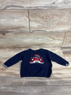 Navy blue toddler sweater with red car graphic, long sleeves, laid on wood floor