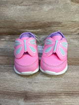 Pink toddler shoes with butterfly wings on wooden background