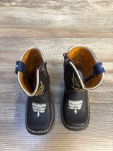 Dark brown toddler boots with cat embroidery, side zippers, and blue ankle straps on wood floor