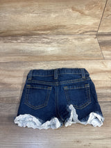Back view of Cat & Jack denim toddler shorts showcasing eyelet lace trim and frayed hem on wood floor background