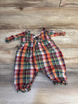 Plaid long sleeve baby romper in red, green, and orange on wood background