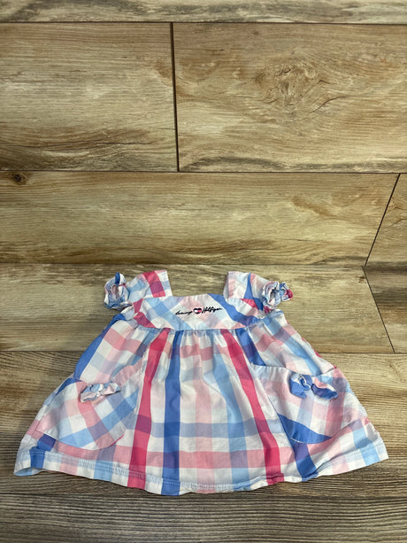 Baby dress with pink and blue plaid pattern, short sleeves, and bow accents on wood floor