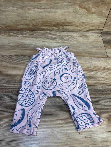 Flat lay of newborn pink Cat & Jack jumpsuit showing blue fruit print and leg snap closures on wood floor
