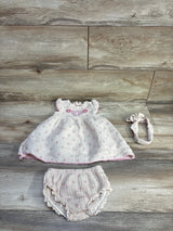 Flat lay of beige 3pc embroidered gauze dress set size 12 months showing smocked embroidered yoke, bloomers and headband on wood