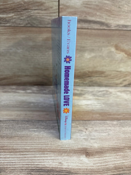 Spine view of Homemade Love board book showcasing its light blue cover and printed title on a wood surface