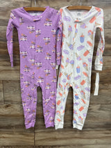 Two long sleeve baby sleepers, one purple with ice cream trucks, one white with dessert prints.