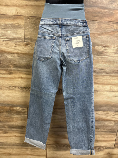 Rear view of H&M Mama maternity straight high-rib jeans showing high rib waistband, back pockets, and cuffed hems on a wooden floor background