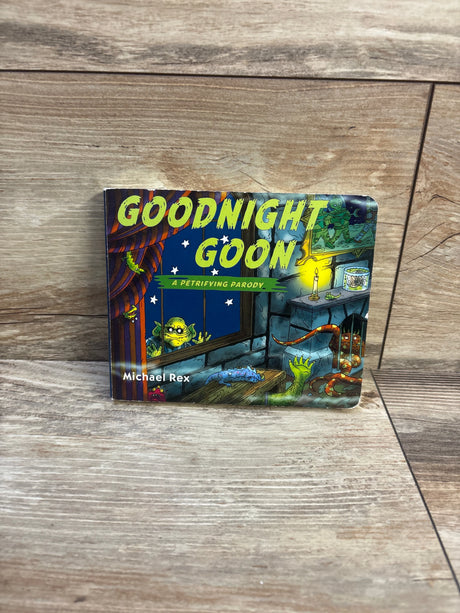 Front cover of Goodnight Goon board book showing large yellow title text and monster illustrations on a wood background