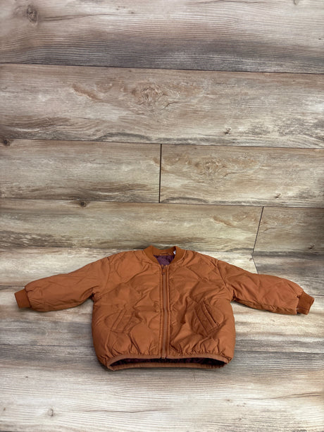 Front view of Zara brown quilted puffer jacket, size 3/4T, showcasing zip front and side pockets on wood flooring