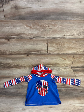 Front view of baby hooded rash guard with American flag skull on blue body, stars and stripes hood and sleeves on wood floor