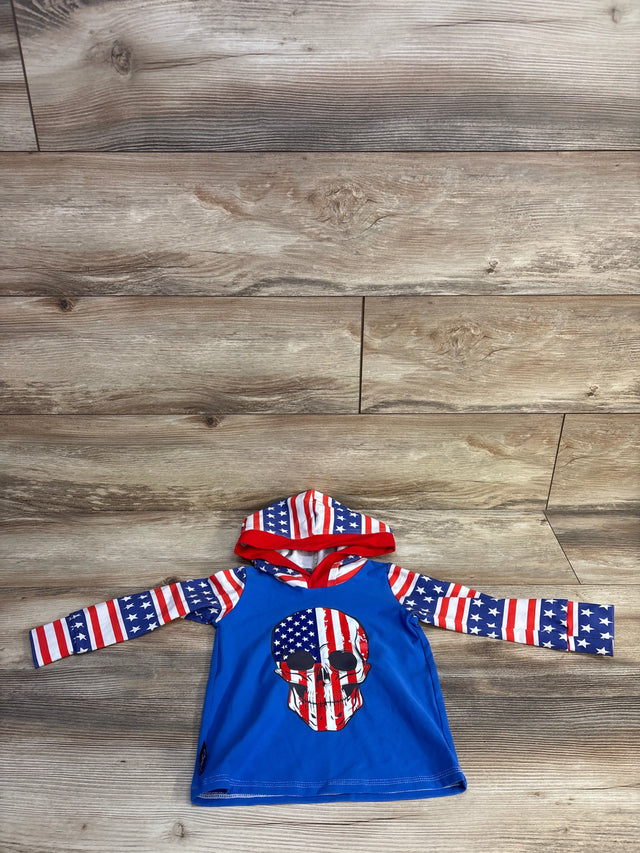 Front view of baby hooded rash guard with American flag skull on blue body, stars and stripes hood and sleeves on wood floor
