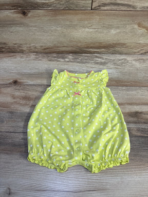 Flat lay of lime polka dot baby shortie romper with front snap buttons, pink bow accents and ruffled sleeves on wood background