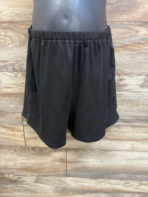 Front view of Ekouaer maternity lounge shorts showcasing an elastic waistband and loose fit with a wood floor background
