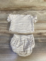 Flat lay of newborn ribbed two-piece shirt and bloomers showing ivory thin stripes and ruffled sleeves on wood background