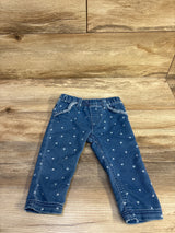 Front view of Cat & Jack blue baby jeggings showing white heart print and elastic waistband on wood background