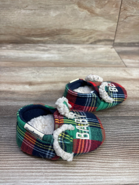 Close-up of Dearfoams baby bear slippers in size 4C showcasing multicolor plaid fabric and fuzzy lining on a wood surface