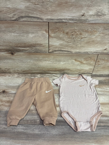 Nike 2pc tan viscose bodysuit and joggers set for infants on a wooden background