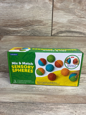 Front view of Lakeshore Mix & Match Sensory Spheres box showcasing colorful textured balls and twist-open mix feature on a wood floor background