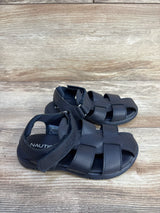Angled view of navy Nautica toddler fisherman sandals showing woven straps and Velcro ankle strap on light wood floor