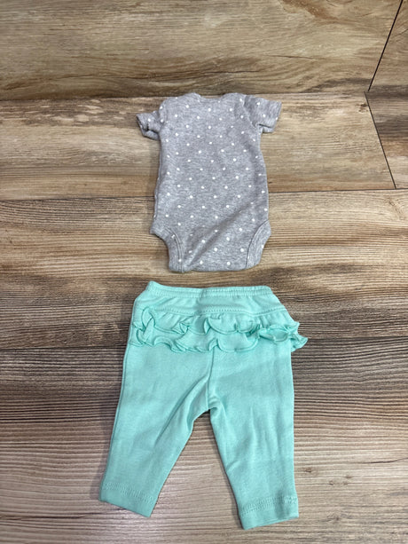 Top down view of Simple Joys two piece set with a gray polka dot bodysuit and turquoise ruffled pants on wood