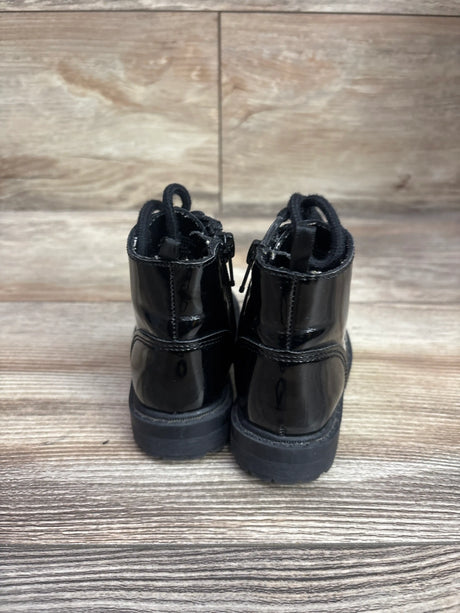Rear view of Old Navy black combat boots showcasing glossy uppers and pull tabs on a wood-look background
