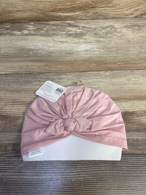 Top-down view of baby turban showcasing front knotted detail in light pink on wooden tabletop background