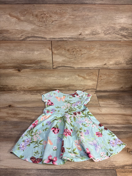 Flat lay of Children's Place blue toddler dress showcasing butterfly and floral print, flutter sleeves, and full twirl skirt on wood background