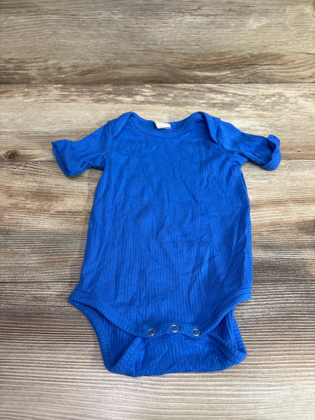 Kate Quinn ribbed modal blue baby bodysuit for 3-6 months on a wooden background