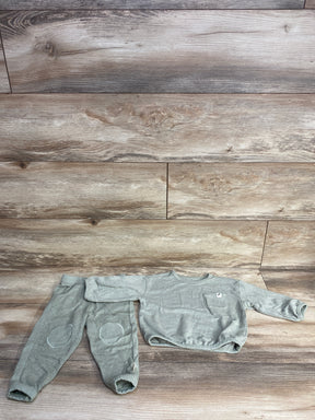 Light grey cotton toddler outfit with long sleeves and pants on wood floor background