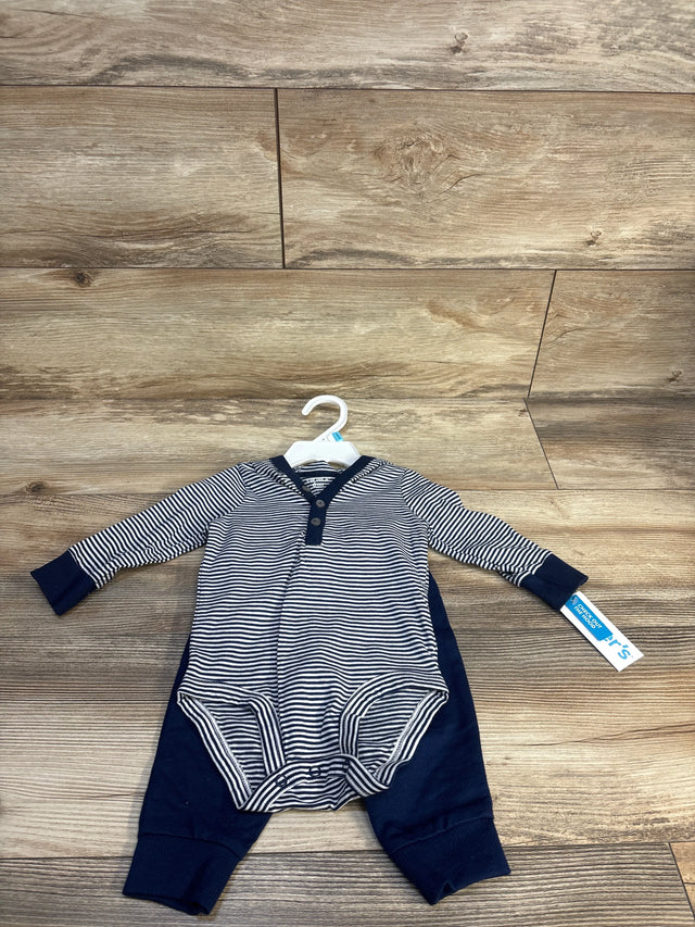 Striped long sleeve baby romper navy blue and white with button front, laid on wood floor