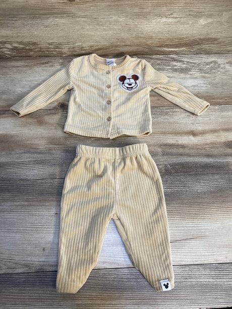 Beige ribbed baby outfit set with bear face on top and matching pants, laid on wood surface.