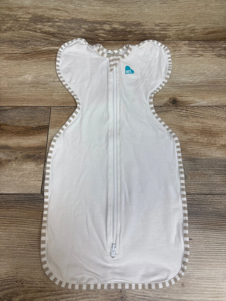 Front view of Love To Dream Swaddle Up Stretch Organic Cotton in white with a full length front zipper on a wood surface