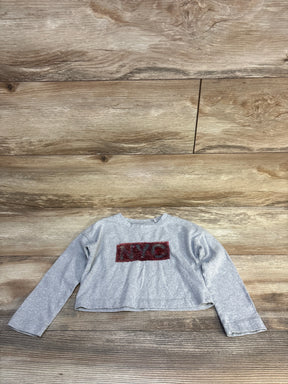 Gray long sleeve kids shirt with red NYC graphic, laid flat on wooden surface