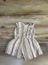 Flat lay of striped shortie romper in white and pink with ruffle shoulders, buttons and elastic waist on wood background