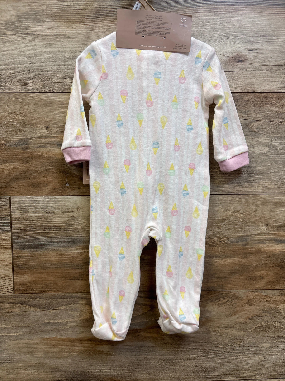 Front view of Chick Pea ice cream sleeper and headband set showing pink sleeper with pastel ice cream print on wood background