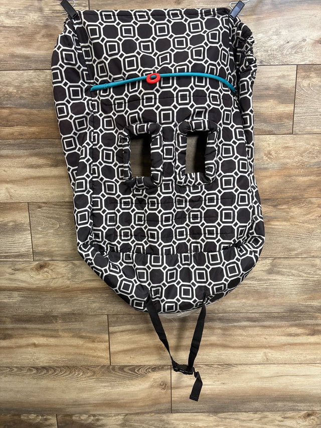 Top-down view of Boppy shopping cart and high chair cover showing black-and-white geometric padding, three harness slots, teal cord, and straps on wood floor