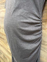 Close-up of gray Motherhood Maternity bodycon dress showcasing ruched side detailing on a wood floor