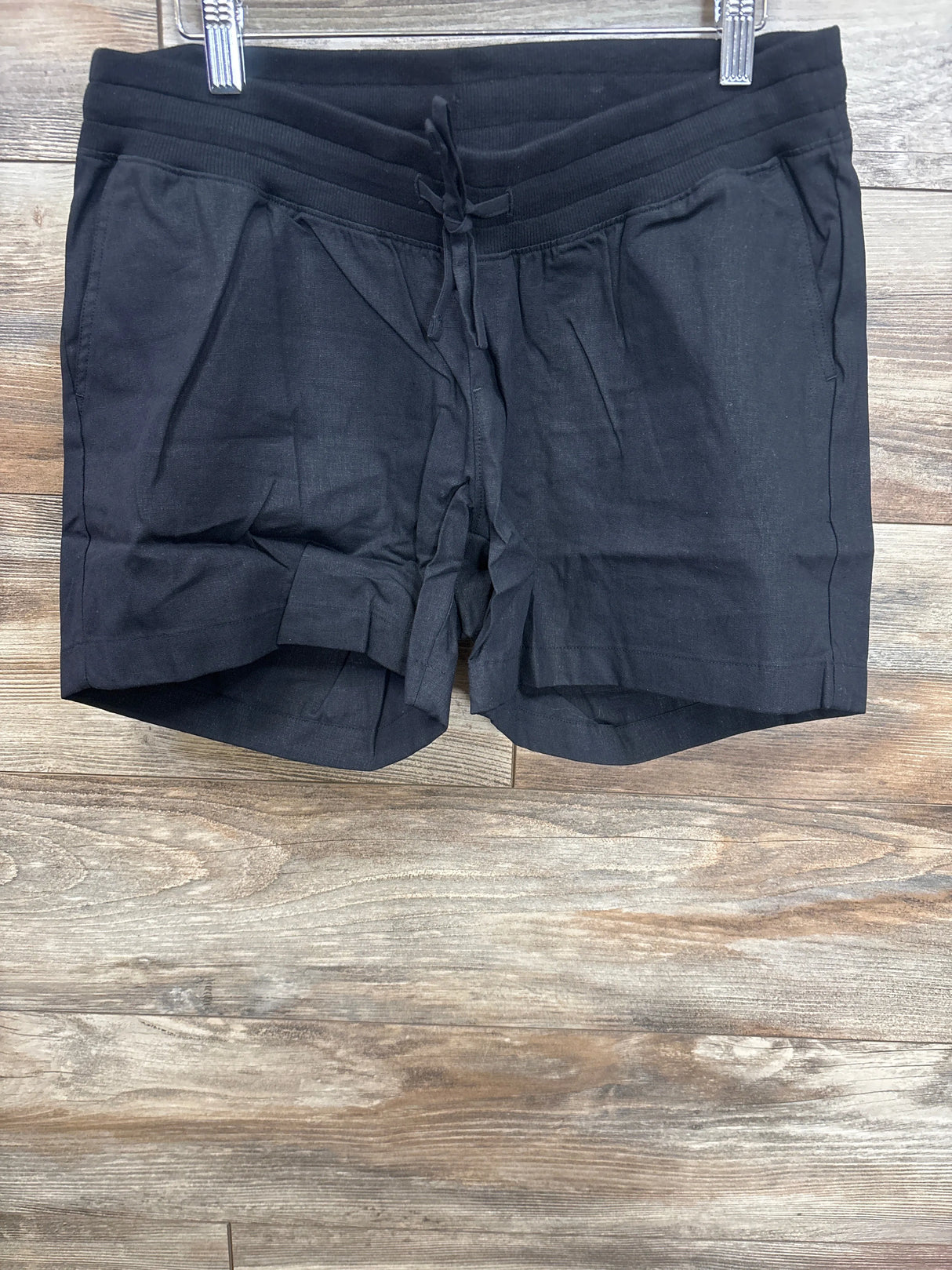 Black maternity shorts with drawstring waist, soft fabric, side pockets, displayed on hanger for resale