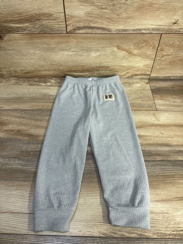 Flat lay of grey ribbed toddler pants showcasing elastic waistband and cuffed ankles on wood floor background