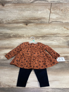 Flat lay of Child Of Mine 2-piece brown floral long-sleeve dress with ruffled tiers and black leggings on wood floor