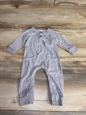 Light gray baby onesie with cloud and lightning bolt prints, long sleeves, snap buttons on legs, on wooden floor